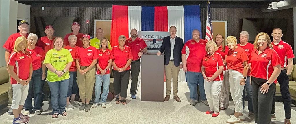 Honor Flight of Southern Indiana, Inc. volunteers pose with Neil Woods at the press conference announcing the sponsorship of EVV21.