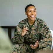 Woman soldier smiling and gesturing to her audience.